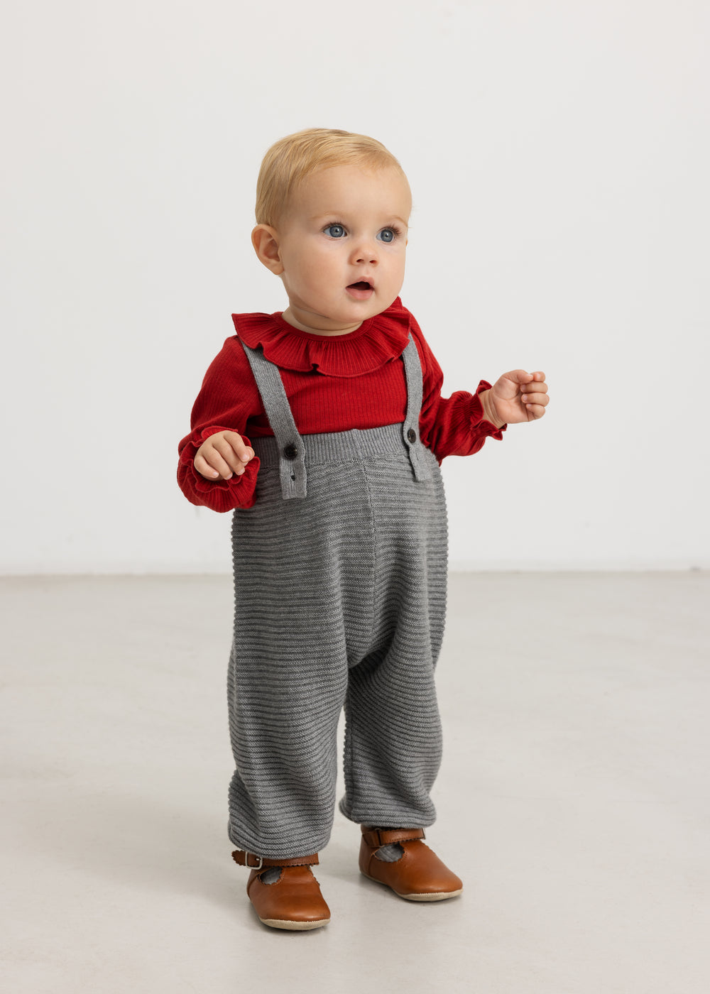 Kirsebærrød bodystocking til baby med flæsekrave og lange ærmer.