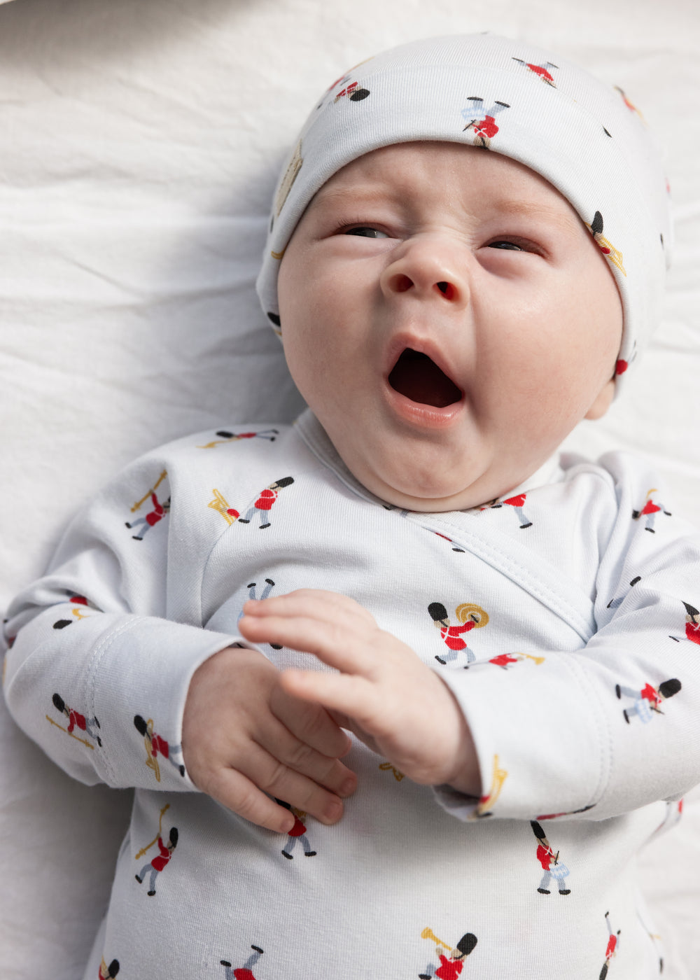 Nyfødt i hvid babyhue med musikermønster