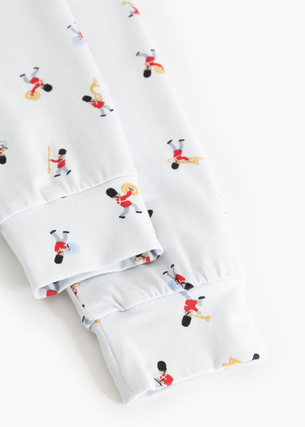 Nærbillede af manchet og benkant på hvid pyjamas med musikerprint
