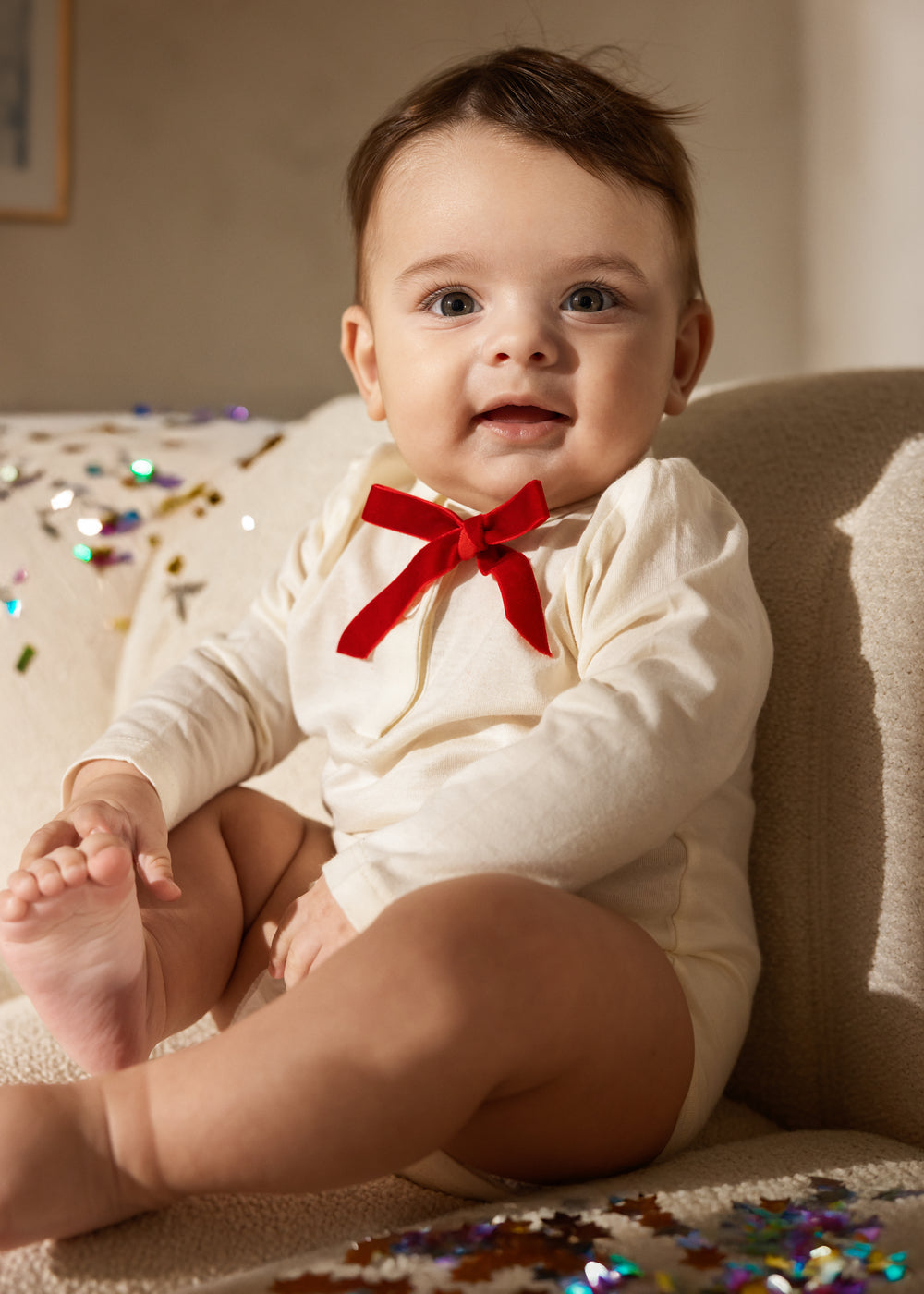 Hvid langærmet babybody med rød sløjfe ved brystet