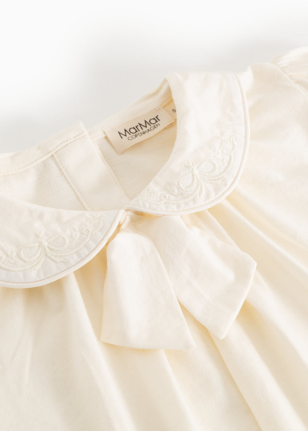 Offwhite bluse med broderet kravekant og blød v-udskæring foran