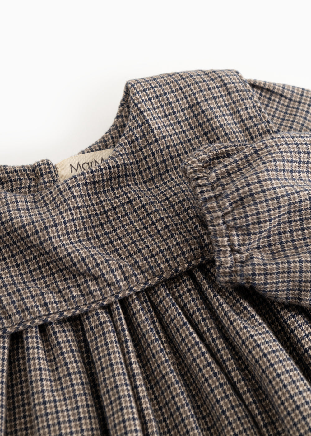 Houndstooth-kjole med flæset krave og rynket brystparti, detalje nærbillede