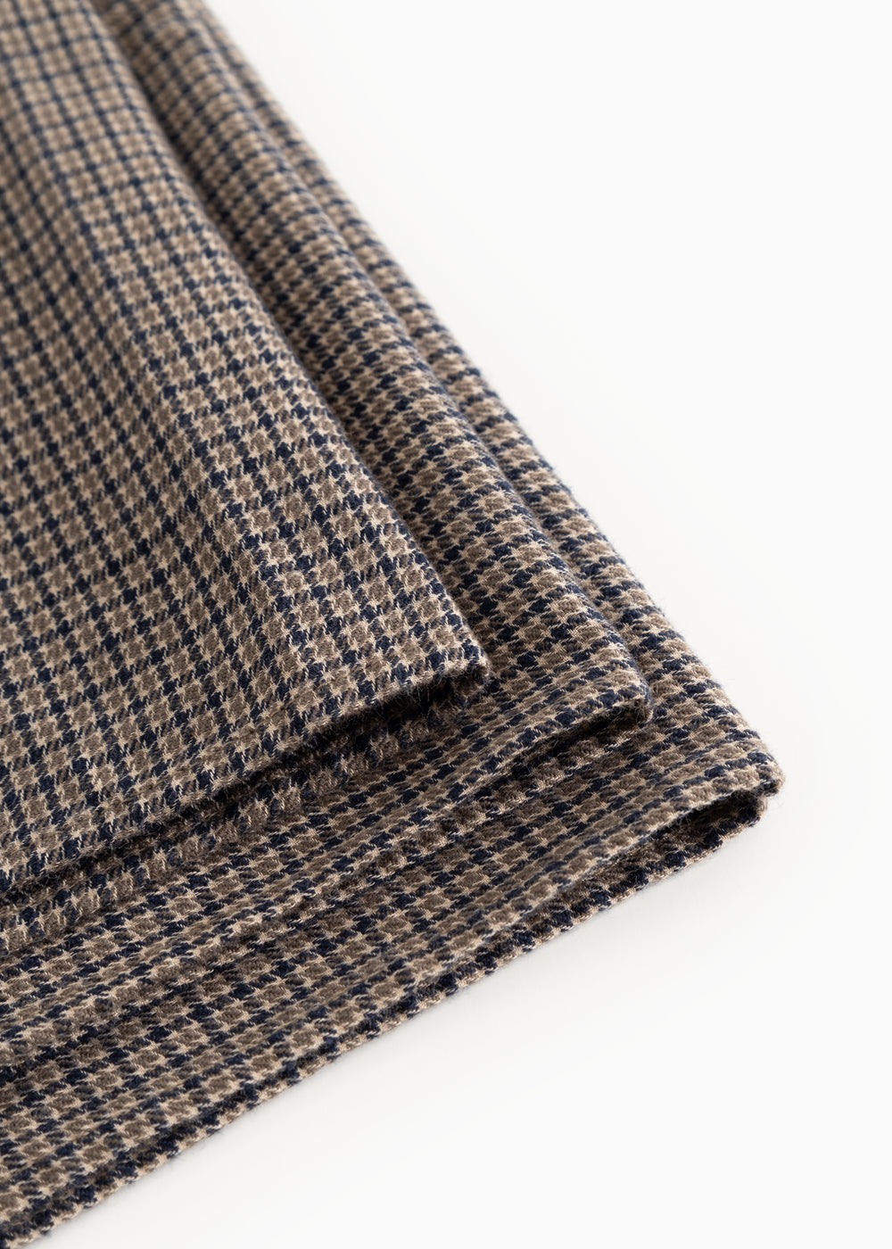 Airo tørklæde med houndstooth-tern, synlig frynsekant og fold i brun og blå