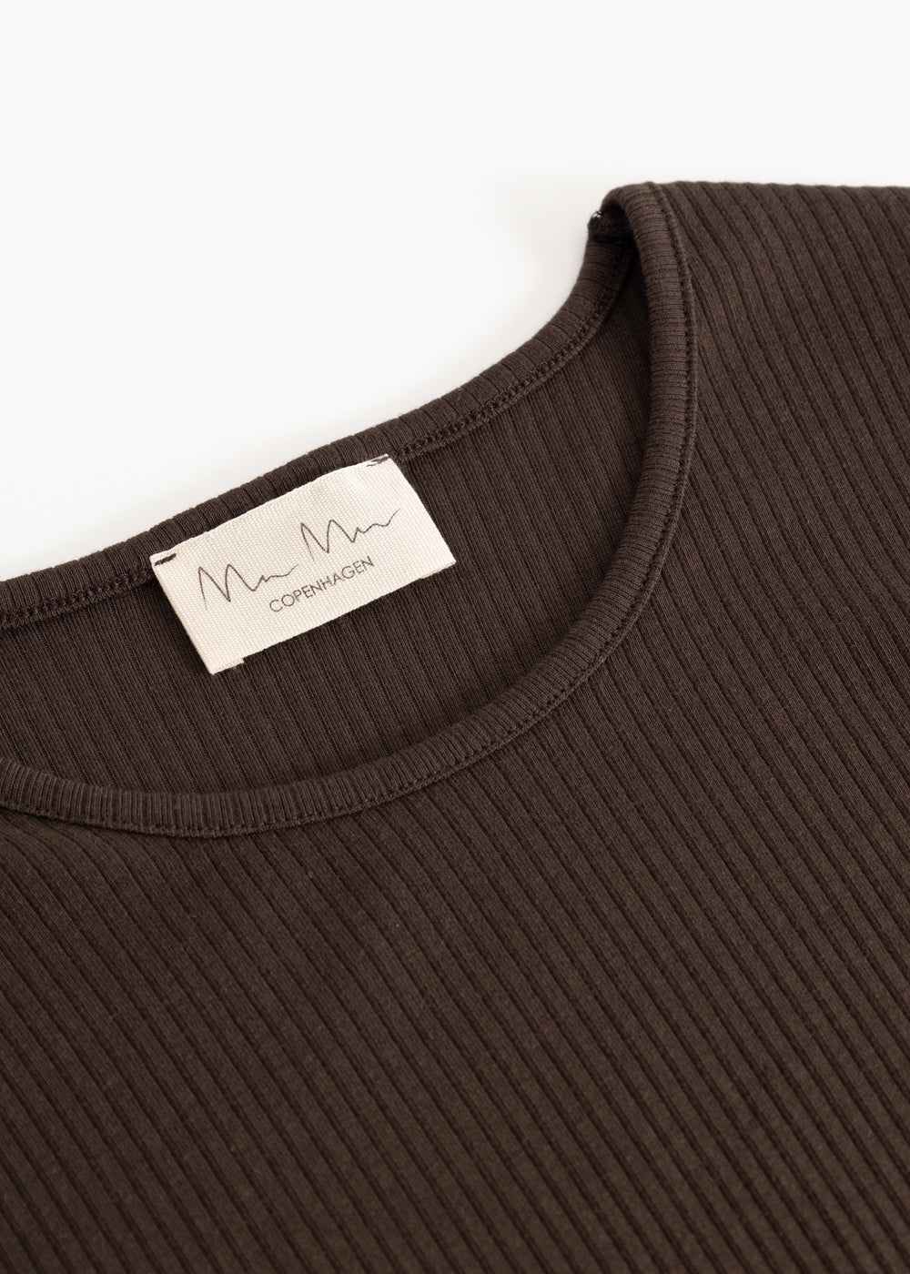 Langærmet T-shirt i mørk brun med rund hals og mærke ved halsudskæring.