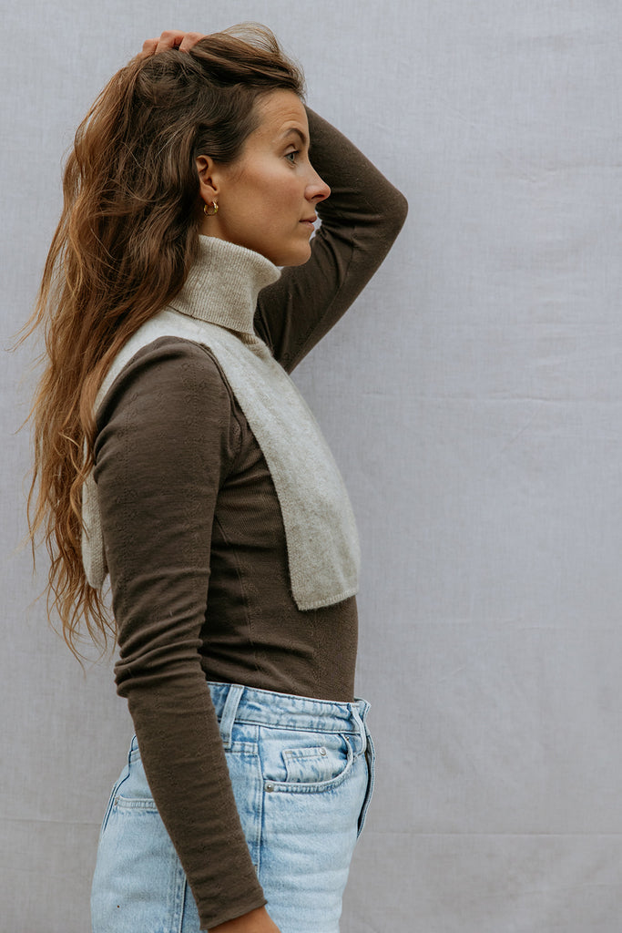 Strikket halsedisse i lys beige med høj krave, som turtleneck ved halsen.