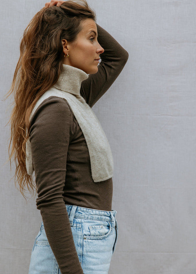 Strikket halsedisse i lys beige med høj krave, som turtleneck ved halsen.